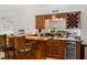 A basement bar with wood cabinets, a mirrored backsplash, and seating for entertaining at 2010 Stonehedge Rd, Roswell, GA 30075