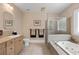 Bright bathroom featuring a soaking tub, glass shower, and wood cabinets at 2010 Stonehedge Rd, Roswell, GA 30075