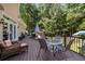 Inviting outdoor living space featuring a comfortable seating area and dining set on a wooden deck overlooking a lush backyard at 2010 Stonehedge Rd, Roswell, GA 30075