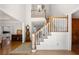 Elegant foyer features hardwood floors, staircase, and a view to the kitchen at 2010 Stonehedge Rd, Roswell, GA 30075