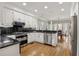 Well-appointed kitchen with white cabinets, granite countertops, stainless steel appliances and eat-in breakfast area at 2010 Stonehedge Rd, Roswell, GA 30075