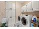 Laundry room with washer, dryer, and ample cabinet space at 2010 Stonehedge Rd, Roswell, GA 30075