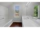 Bright bathroom with dual sinks, a bathtub and a window with green views at 3384 Brookside Ln, Jonesboro, GA 30236