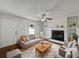 Comfortable living room featuring a fireplace, ceiling fan, and stylish decor at 3384 Brookside Ln, Jonesboro, GA 30236