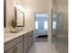 Bright bathroom with double vanity, white countertops, and glass shower overlooking bedroom at 630 Skytop Dr # 157, Cumming, GA 30040