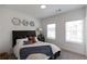 Bedroom with dark wood accents, neutral color scheme, and natural light from two windows at 630 Skytop Dr # 157, Cumming, GA 30040