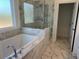 Spa-like bathroom with marble tile, soaking tub, and glass-enclosed shower at 621 Silva St # 124, Cumming, GA 30040