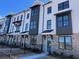 Modern townhome featuring white brick, dark accents, large windows, and professionally landscaped grounds at 621 Silva St # 124, Cumming, GA 30040