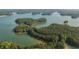 Aerial view of forest and waterfront homes surrounded by lush forest and serene lake waters at 635 Skytop Dr, Cumming, GA 30040