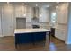 Bright kitchen featuring white cabinets, stainless steel appliances, and a dark blue center island with a white countertop at 635 Skytop Dr, Cumming, GA 30040