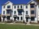 Townhomes featuring white siding, black trim, and lush landscaping at 631 Silva St # 129, Cumming, GA 30040