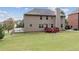 View of the home's backyard, featuring a well-manicured lawn, a wooden deck and siding, and an exterior chimney at 932 Nestling Dr, Lawrenceville, GA 30045