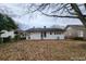 The backyard features mature trees, leaf-covered ground, and a view of the home's rear exterior at 1012 Burns Dr, Atlanta, GA 30310