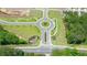 Aerial view of new home community with manicured roundabouts and landscaped common areas bordered by mature trees at 8588 Seabiscuit Rd, Lithonia, GA 30058