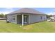 Home's backyard featuring a covered patio, well-maintained lawn, and an exterior view at 8588 Seabiscuit Rd, Lithonia, GA 30058