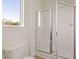 This bright bathroom is equipped with a glass-doored walk-in shower and a window view at 8588 Seabiscuit Rd, Lithonia, GA 30058