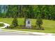 Community entrance with stone monument, lush landscaping, and a welcoming path leading into the neighborhood at 8588 Seabiscuit Rd, Lithonia, GA 30058