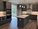 Modern kitchen features sleek gray cabinets, a center island with marble countertop, and stainless steel appliances at 1065 Low Water Nw Xing, Acworth, GA 30101