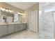 Elegant bathroom featuring double sinks, marble countertops, and a glass-enclosed shower at 5365 Maggie Mae Ln, Cumming, GA 30028