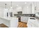 A modern eat-in kitchen features white cabinetry, stainless appliances, granite countertops and an island with bar seating at 104 Cottage Gate Ln, Roswell, GA 30076