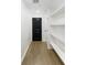 Hallway with hardwood floors, shelving, and sleek dark colored door at 371 Pratt Se Dr # 203, Atlanta, GA 30315