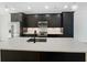 Modern kitchen features sleek dark cabinets, stainless appliances and a spacious island at 371 Pratt Se Dr # 203, Atlanta, GA 30315