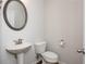 Half bathroom features a pedestal sink and oval mirror at 2539 Hedgeway Cir, Kennesaw, GA 30144