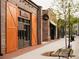 Commercial space with large wooden sliding doors and brick facade along a landscaped sidewalk at 626 Skytop Dr # 159, Cumming, GA 30040