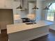Bright kitchen featuring a large island, white cabinets, stainless appliances, and hardwood floors at 629 Silva St # 128, Cumming, GA 30040