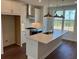 Spacious kitchen featuring a large island, white cabinets, stainless appliances, and hardwood floors at 629 Silva St # 128, Cumming, GA 30040