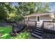 Landscaped backyard with lush lawn and mature trees surrounding a well maintained gray painted deck at 2121 Arlington Ne Ave, Atlanta, GA 30324