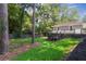 Manicured backyard boasts a lush lawn, mature trees, and gray wooden deck, blending nature with comfort at 2121 Arlington Ne Ave, Atlanta, GA 30324