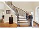 Elegant curved staircase with wrought iron balusters at 2269 E Cherokee Dr, Woodstock, GA 30188