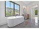 Bright bathroom featuring a modern tub, large window with natural light, and sleek tile flooring at 8200 Main St # 1206, Woodstock, GA 30188