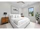 Cozy bedroom with neutral tones, featuring a comfortable bed, artwork, and ample natural light from the window at 8200 Main St # 1206, Woodstock, GA 30188
