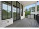 Outdoor patio features dark railings, a wood deck, and black framed windows overlooking the surrounding foliage at 8200 Main St # 1206, Woodstock, GA 30188