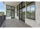 Large open air patio features a wood deck, dark railings, and black framed windows overlooking the neighborhood foliage at 8200 Main St # 1206, Woodstock, GA 30188