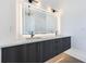 Close-up of a bathroom vanity with dual sinks, modern lighting, and gray wood cabinets at 8200 Main S St # 1208, Woodstock, GA 30188