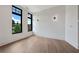 Bright bedroom featuring hardwood floors, two windows with black trim, and stylish sconce lighting at 8200 Main S St # 1208, Woodstock, GA 30188