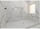 Walk-in shower with Carrara marble walls, white hexagonal tile floors, a built-in soap dish, and a window at 2884 Thompson Cir, Decatur, GA 30034