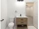 Light and airy half bathroom with a wood vanity, matte black fixtures, and white marble floors at 2884 Thompson Cir, Decatur, GA 30034