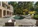 Expansive backyard featuring a pool, spa, and patio, framed by lush landscaping and mature trees at 3560 Ridgewood Nw Rd, Atlanta, GA 30327