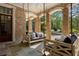 Inviting covered porch featuring swing beds and brick columns overlooking the outdoor space at 3560 Ridgewood Nw Rd, Atlanta, GA 30327