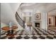 Elegant foyer with a sweeping staircase, fireplace, and checkered marble floors at 3560 Ridgewood Nw Rd, Atlanta, GA 30327