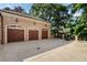 Three-car garage with a basketball hoop and a spacious driveway at 3560 Ridgewood Nw Rd, Atlanta, GA 30327