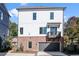 Striking exterior with white siding, brick accents, a two-car garage, and a charming balcony at 3324 Springhaven Ave, Atlanta, GA 30354