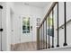 Bright foyer with a glass door, hardwood floors, and a staircase featuring modern black railings at 3324 Springhaven Ave, Atlanta, GA 30354