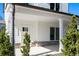 Inviting covered front porch with brick accents and white pillars on a sunny day at 3324 Springhaven Ave, Atlanta, GA 30354