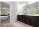 Double vanity bathroom with dark wood cabinets and a view into the bedroom at 2535 Grayton Loop, Villa Rica, GA 30180