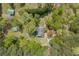 Overhead view of a property in Covington, GA featuring a home, barn, covered patio, and detached garage amid verdant foliage at 3208 Paddock Rd, Covington, GA 30014